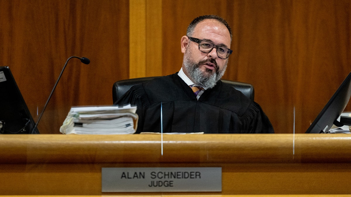 Judge Alan Schneider speaks from behind the bench