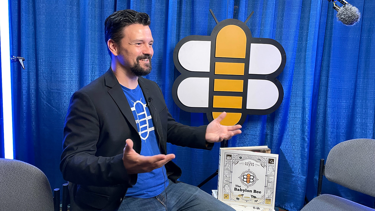 Kyle Mann sits next to the Babylon Bee logo and new book