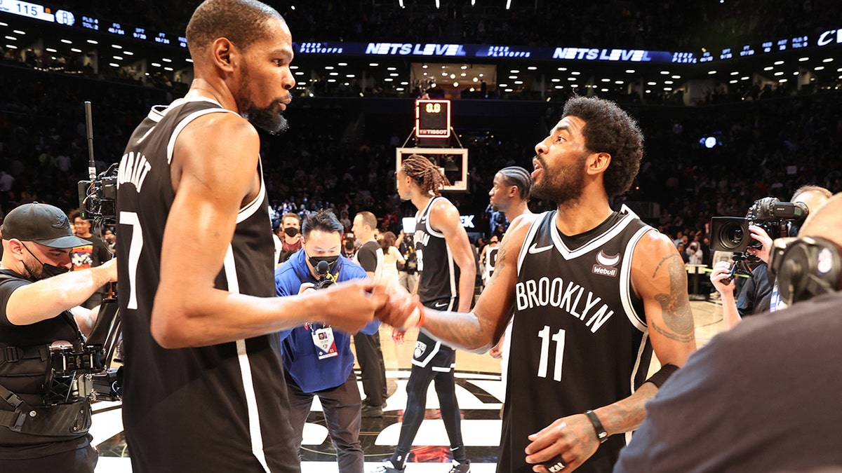 Kevin Durant high-fives Kyrie Irving