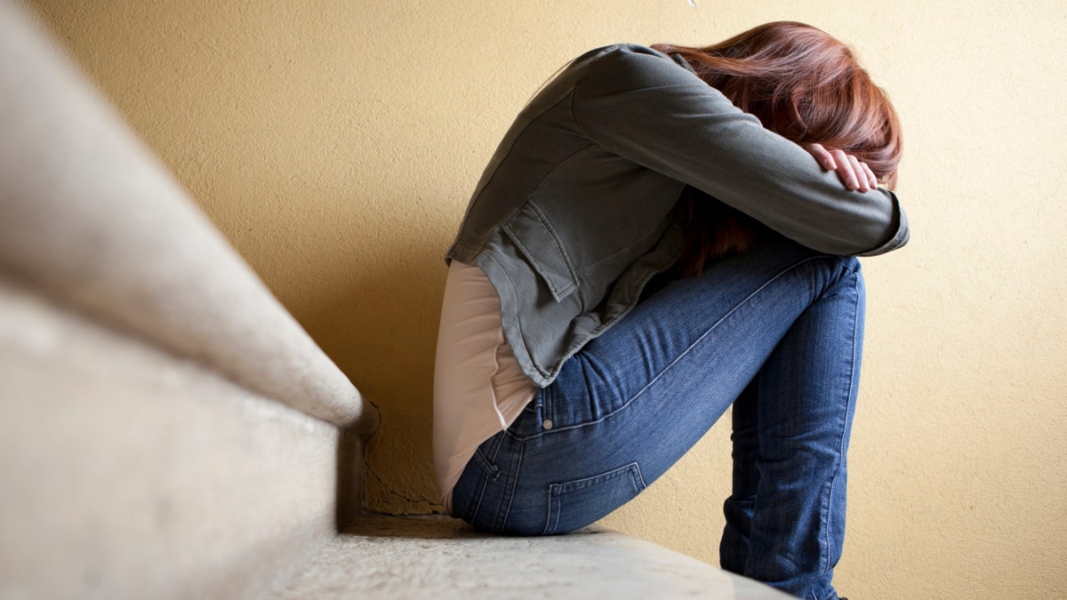 Upset woman resting head on knees