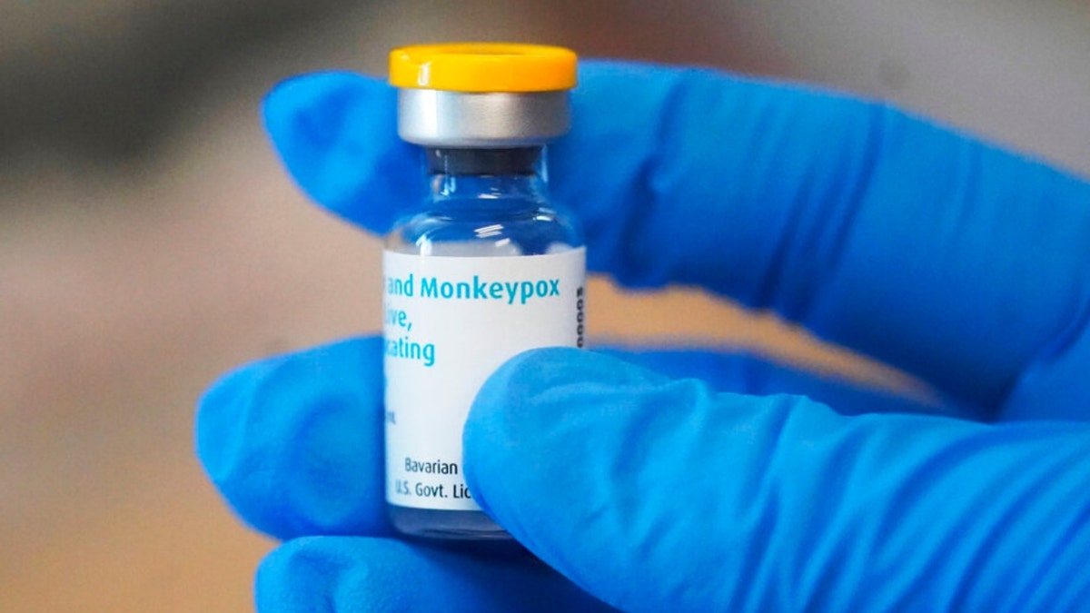 Person wearing gloves holds vial of monkeypox vaccine