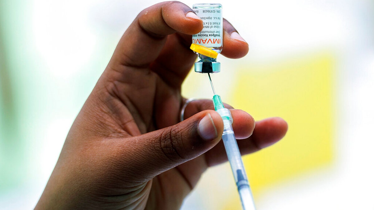 Person holding Monkeypox vaccine and needle