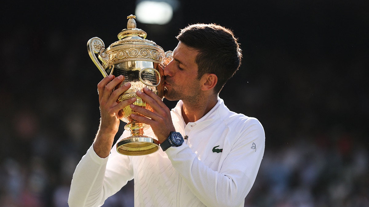 Novak Djokovic kisses the Wimbledon trophy