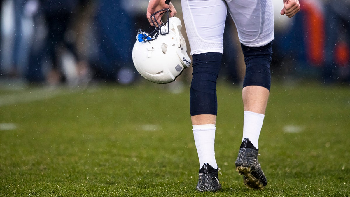 Penn State football helmet carried by a player