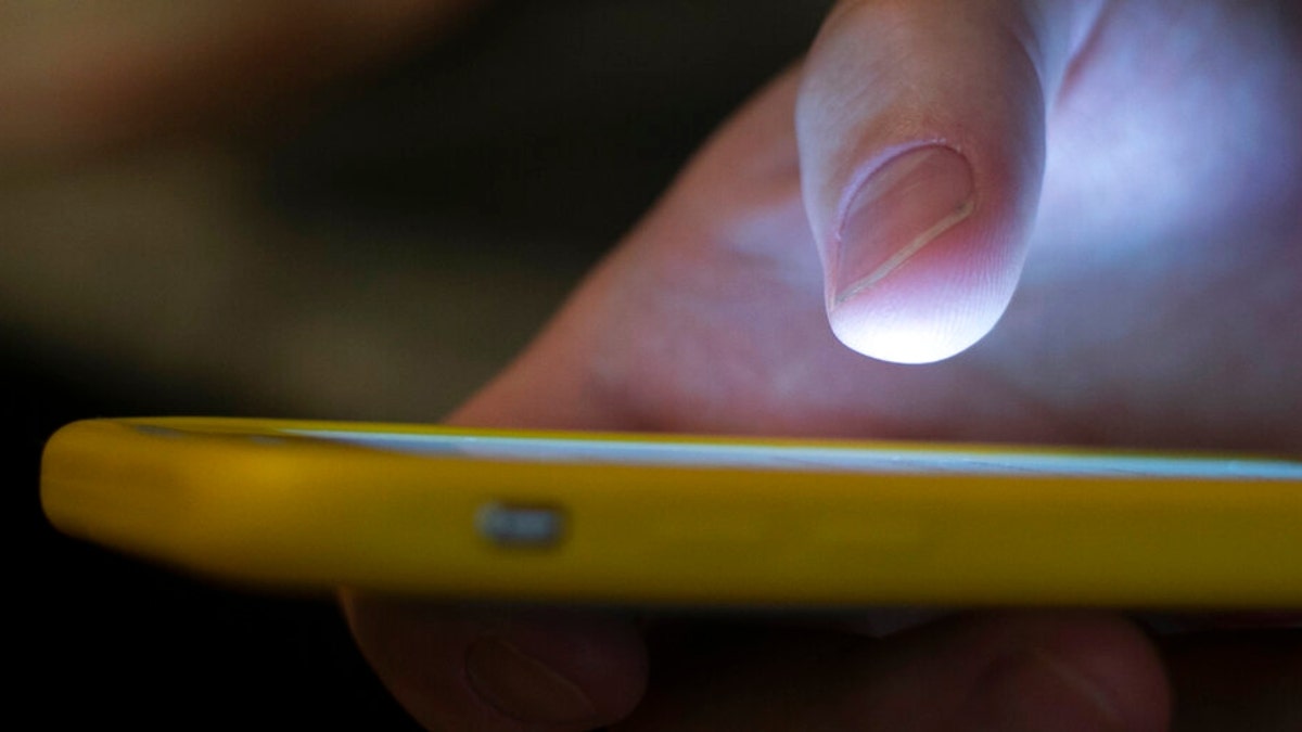 In this photo, a man uses a cell phone in New Orleans. Quick help for suicidal thoughts and other mental health emergencies may soon be as easy as 9-8-8. The United States’ first nationwide three-digit mental health crisis hotline goes live on Saturday, July 16, 2022.