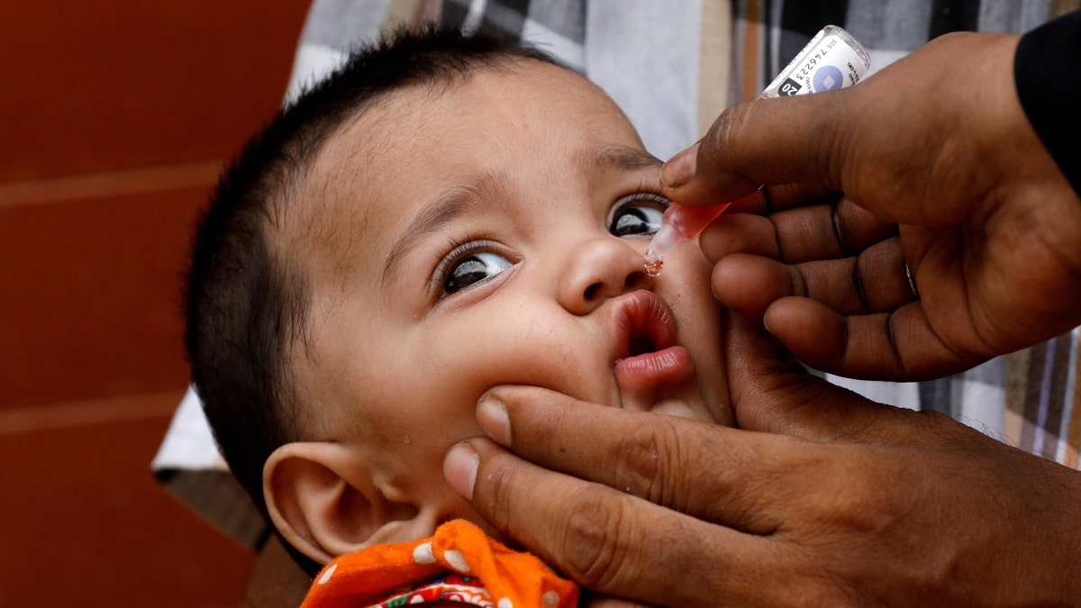 A Pakistan girl gets a polio vaccine