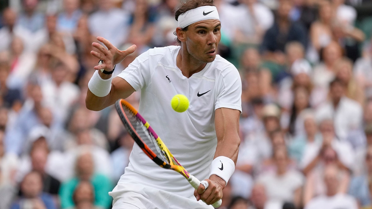 Rafael Nadal returns a shot from Taylor Fritz