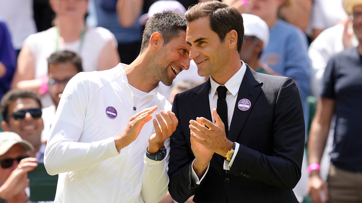 Roger Federer talks with Novak Djokovic