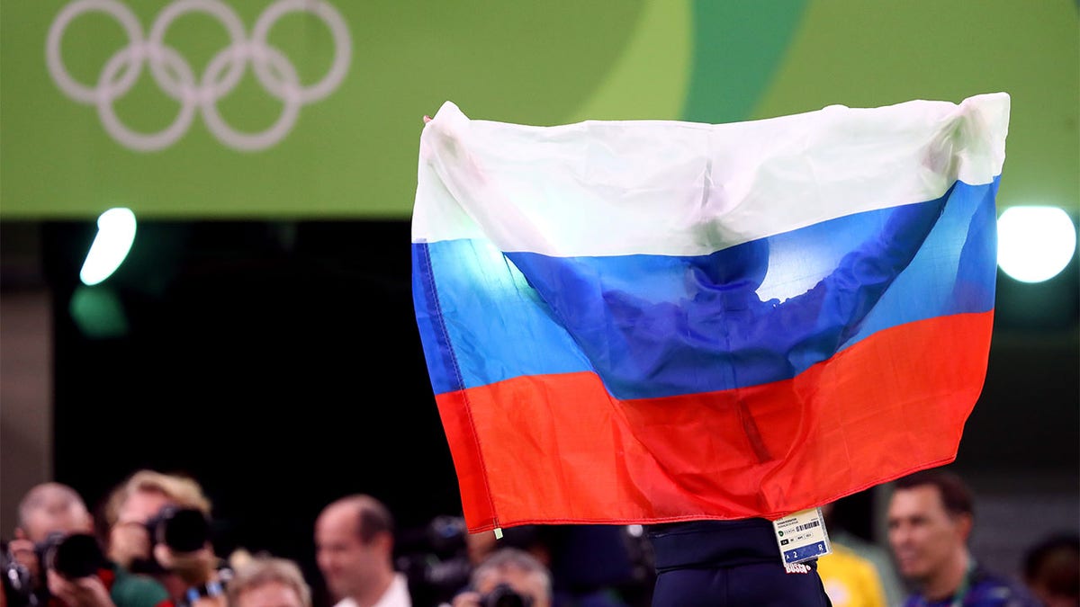 Aliya Mustafina celebrates winning gold medal with the Russian flag