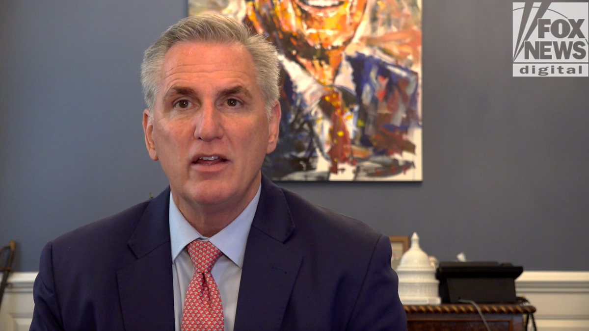 Leader McCarthy in front of his desk