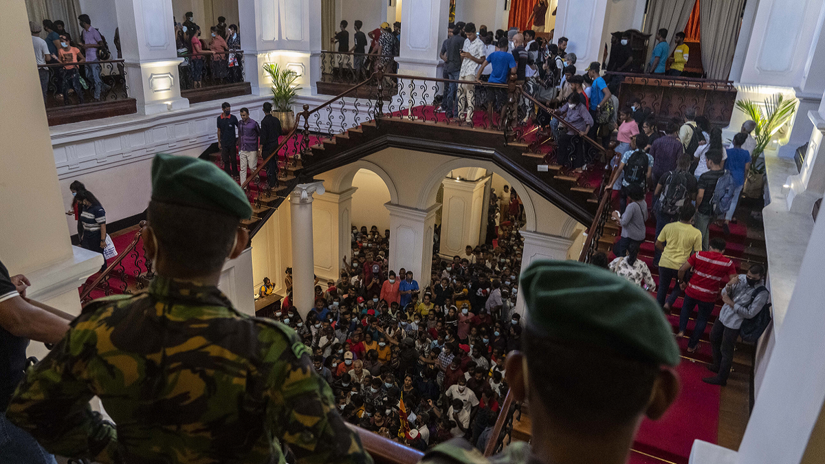 Sri Lanka army officers watch over protesters