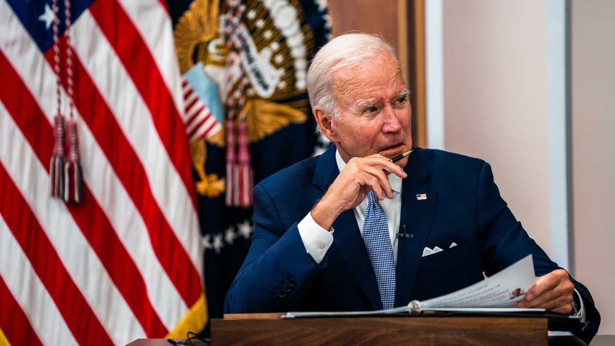 President Biden sitting in front of an American flag
