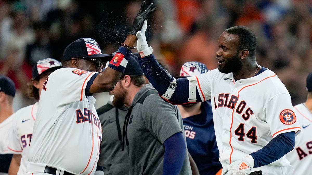 Dusty Baker and Yordan Alvarez celebrate after the game