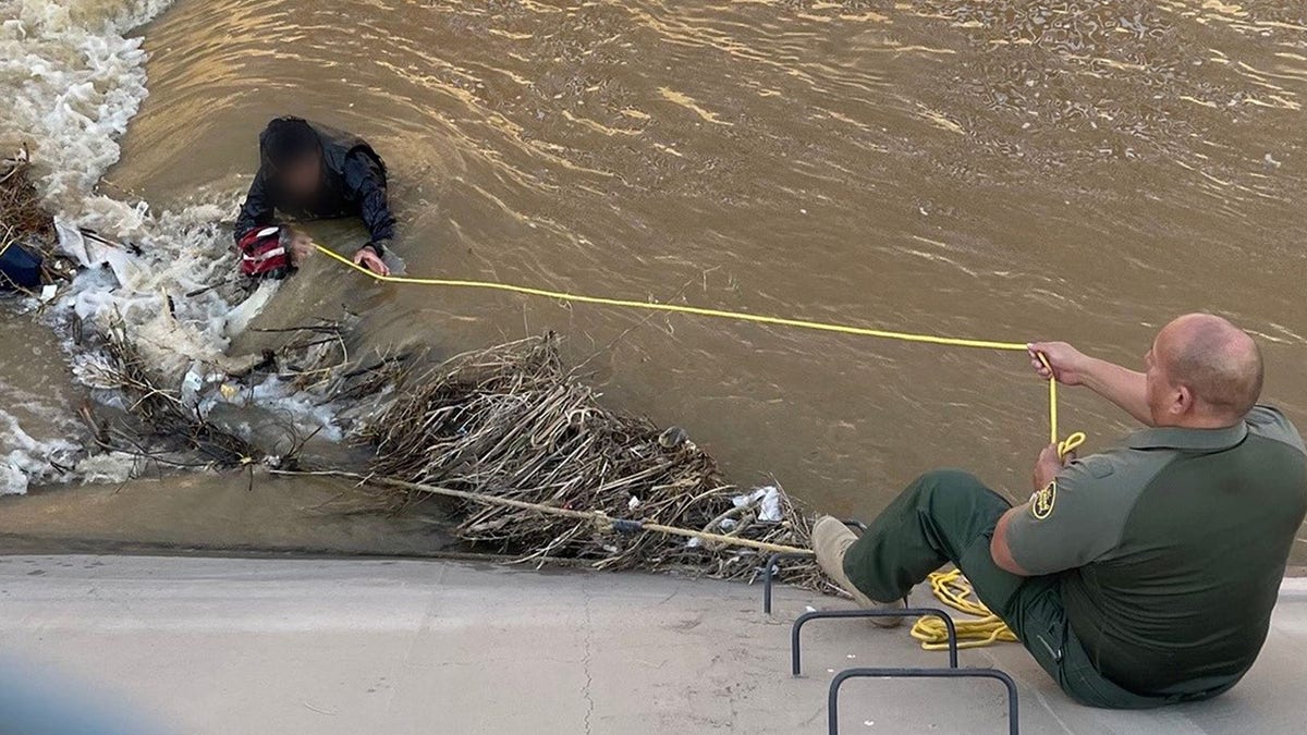 Border agent rescuing migrant from canal