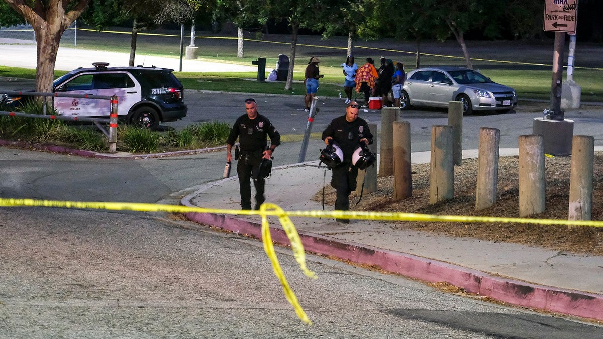 Police walking toward crime scene tape after LA park shooting