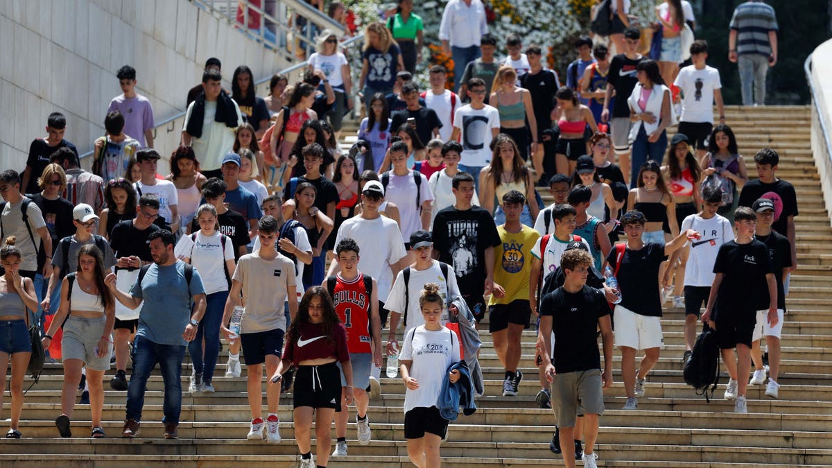 Young people walk near the Guggenheim Museum, in Bilbao, Spain