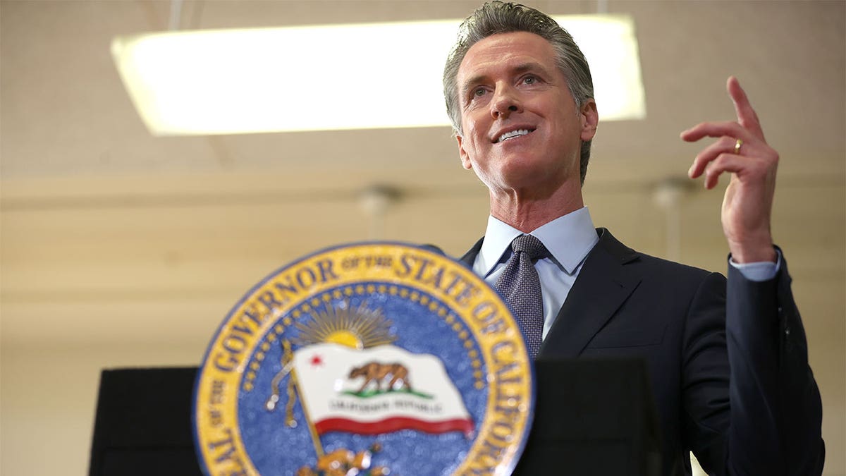 California Gov. Gavin Newsom behind a podium with California seal