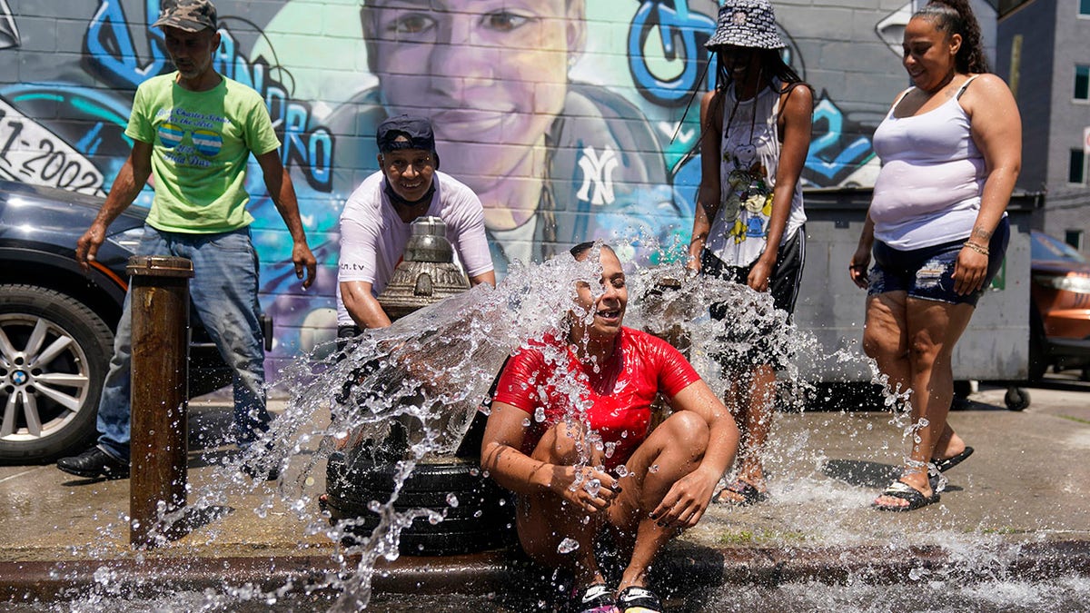 People cooling off with fire hydrant water in hot temperatures