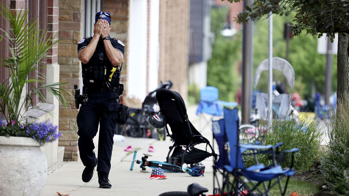 A Lake County, Illinois, police officer walks down Central Avenue in Highland Park on July 4, 2022, after a shooter fired on the northern suburb's Fourth of July parade. At least six people were killed and at least two dozen injured. (Brian Cassella/Chicago Tribune/Tribune News Service via Getty Images)