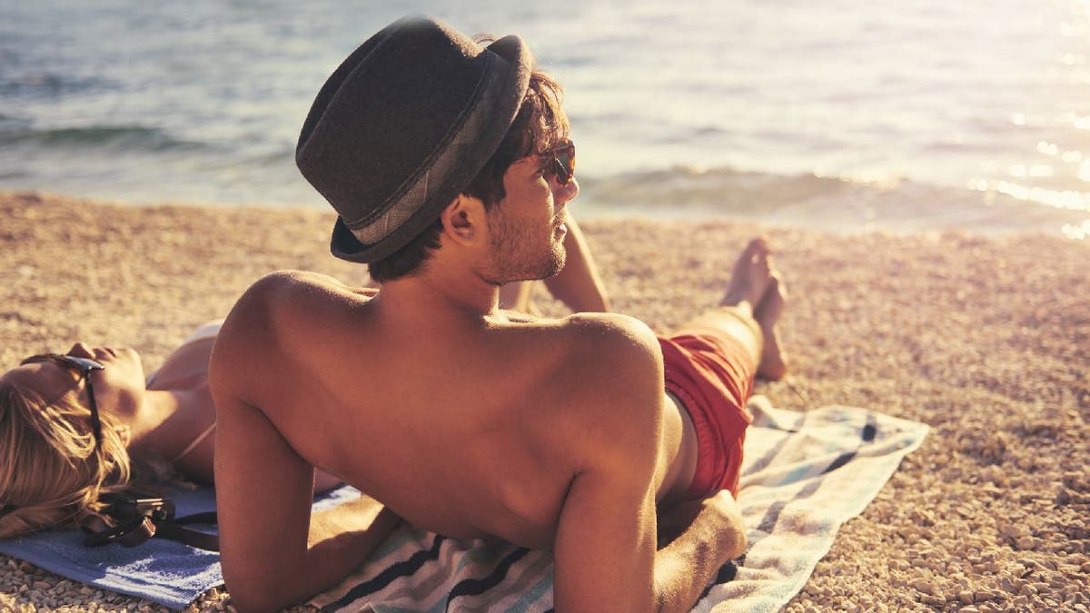 Man sun bathes on beach