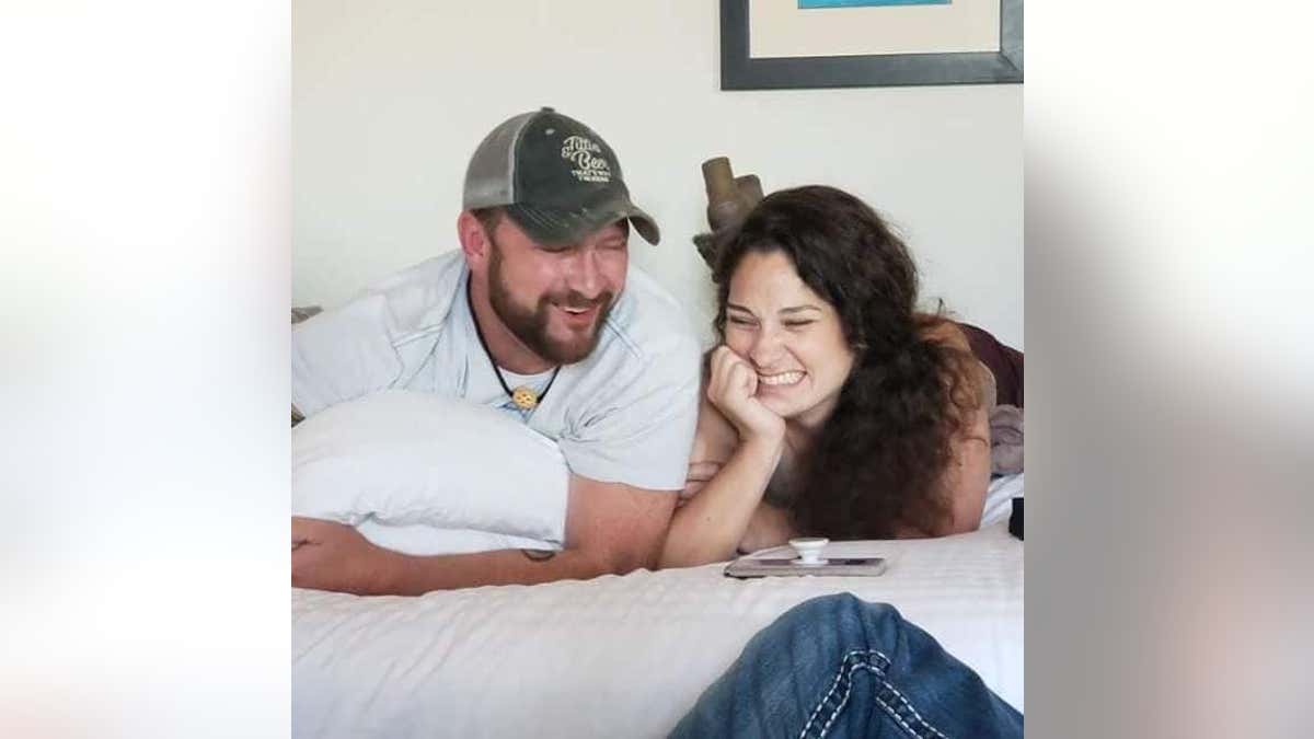 Melanie Rauscher smiling on a bed with former classmate Jeremy McCaa