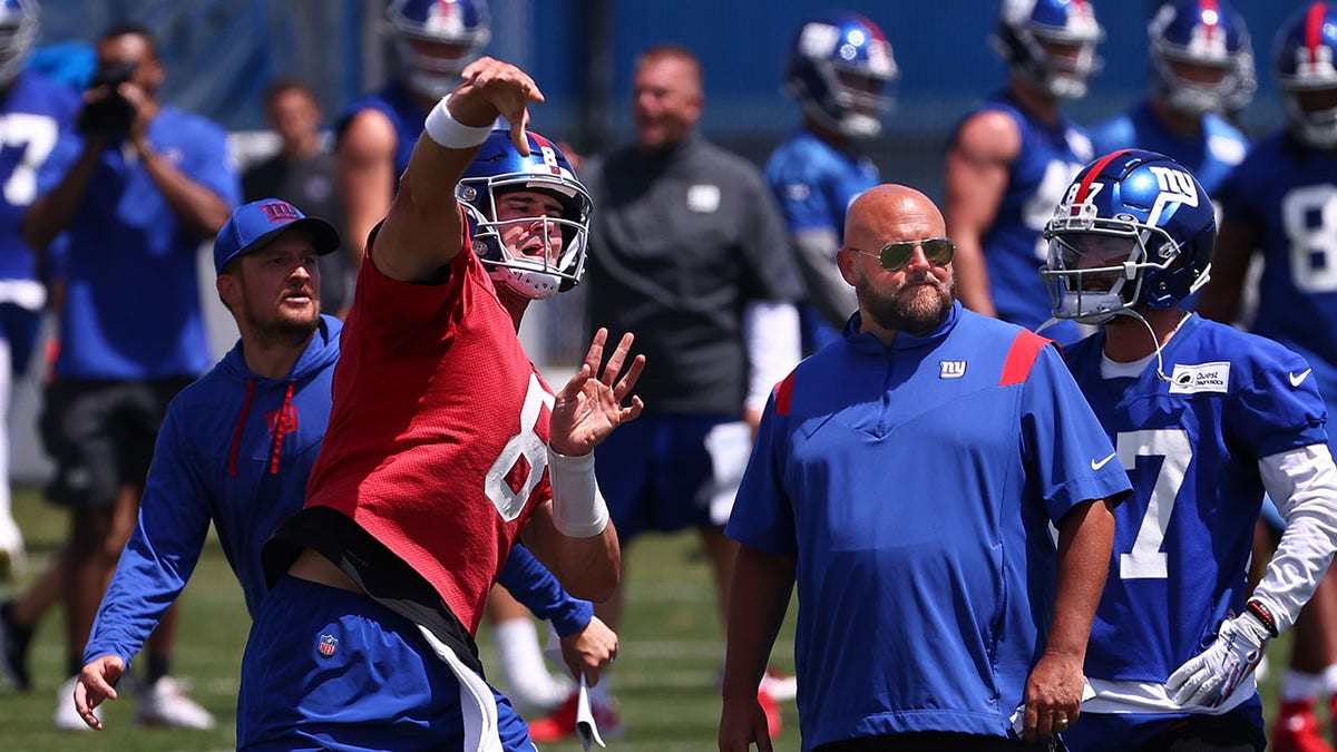 Daniel Jones throws next to Brian Daboll(Photo by Rich Schultz/Getty Images)