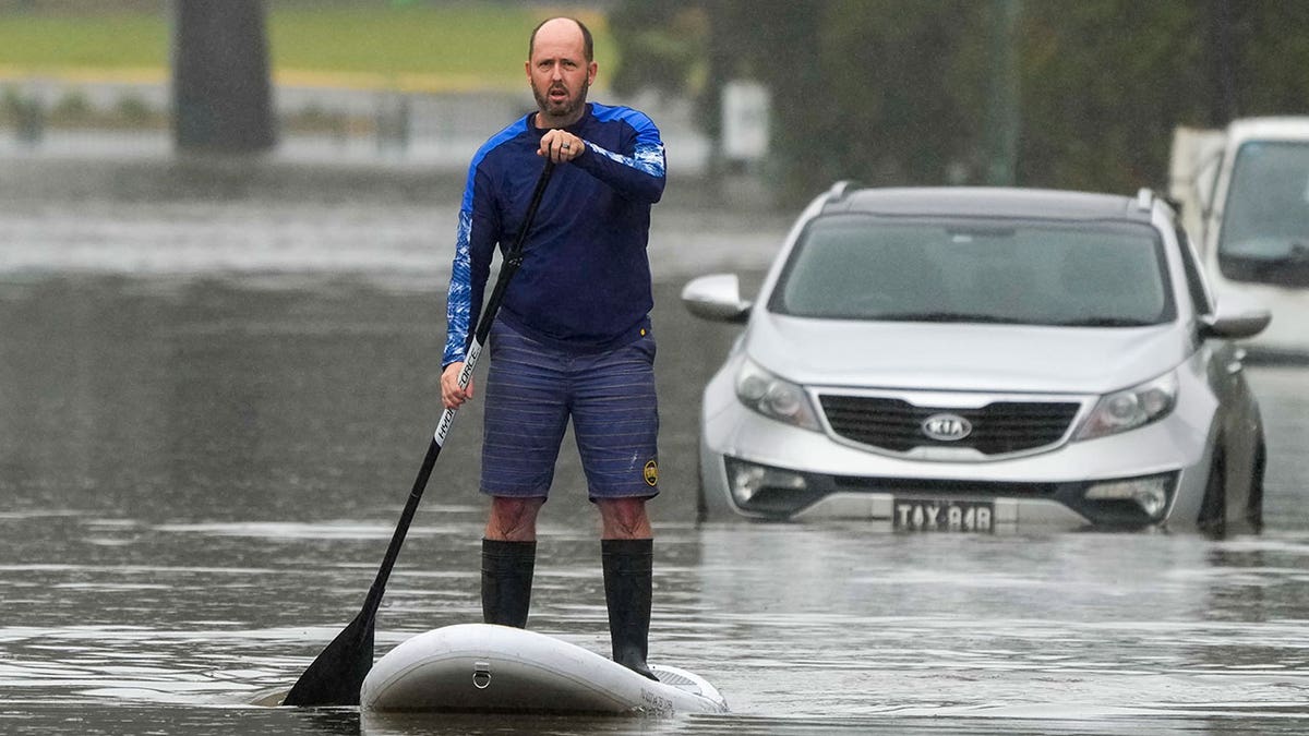 Man paddleboards through Sydney