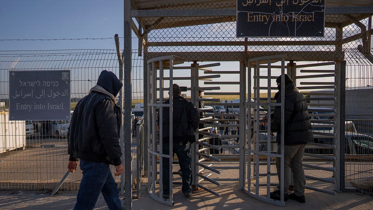 Palestinian workers in Israel at a border fence checkpoint