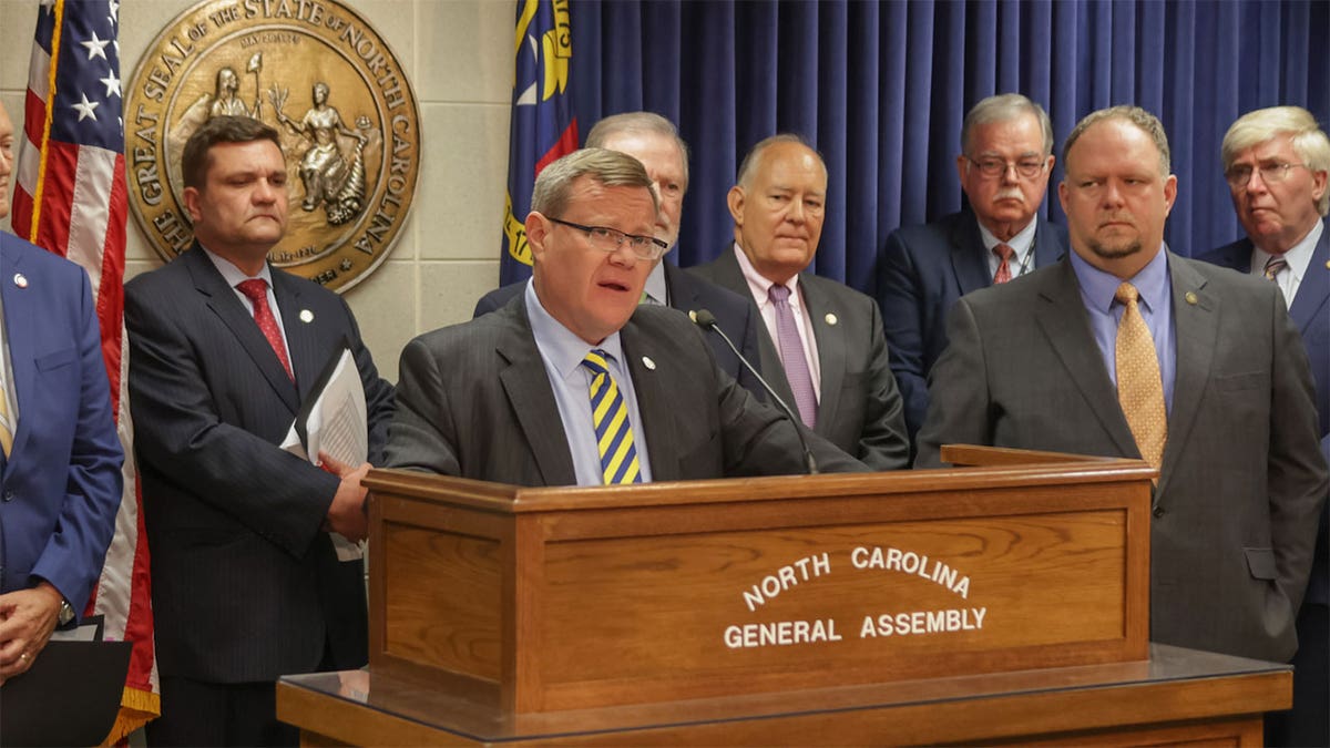 Rep. Timothy Moore and GOP legislature speak while behind a podium