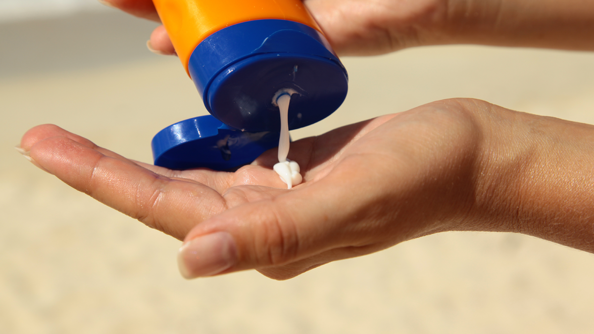Sunscreen being squeezed onto hand