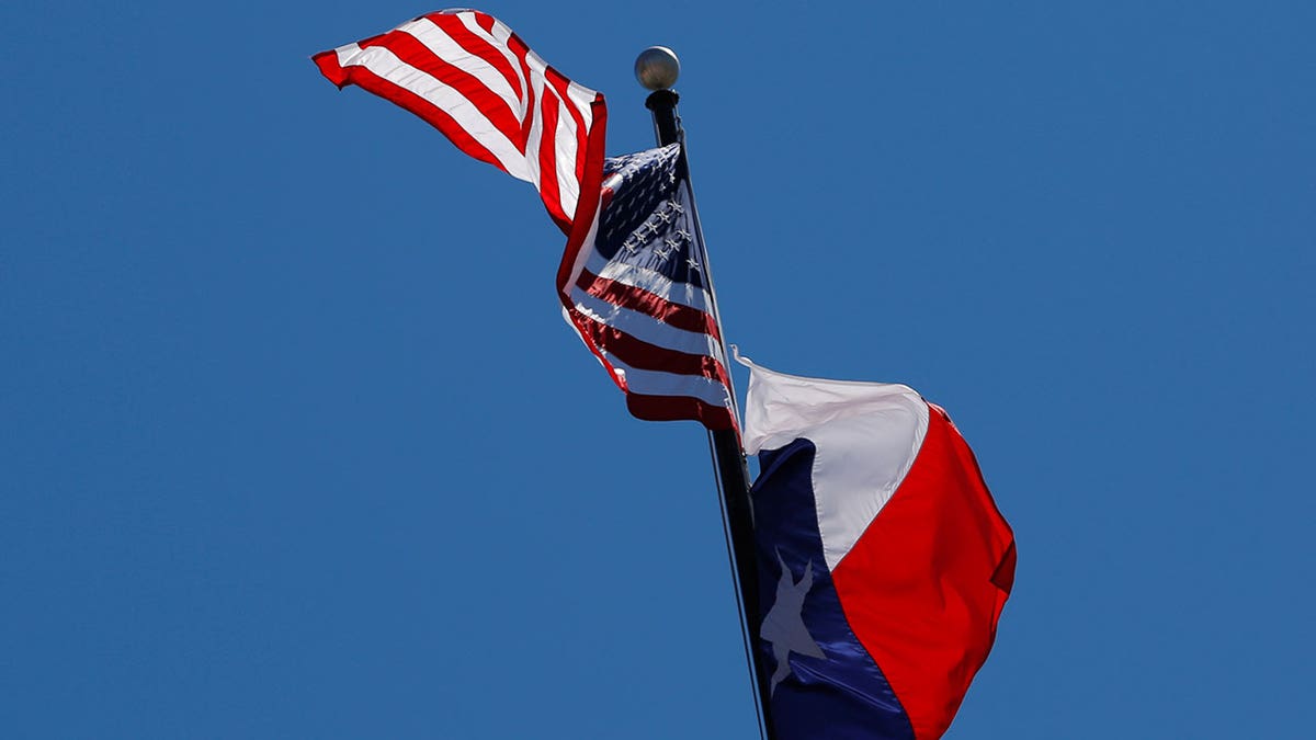 A bandeira dos EUA e a bandeira do estado do Texas voando no ar