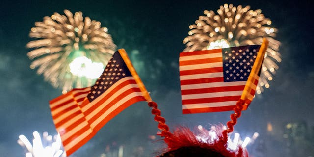 Spectators watch the 45th annual Macy’s 4th of July Fireworks display overlooking the Manhattan skyline at Gantry State Plaza in Long Island City on July 4th in the Queens borough of New York City.