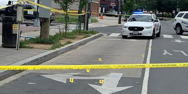 Yellow markers indicate shell casings after three people were injured in a Friday shooting in Washington DC 