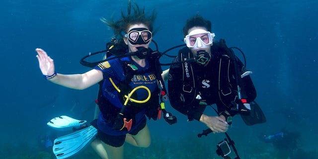 Divers on a coral reef conservation mission pose for the camera underwater in Islamorada, Florida.