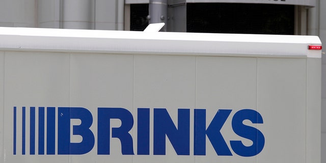 The logo of a Brinks truck is seen near the logo of a Versace store on Rodeo Drive in Beverly Hills, California, May 21, 2013. 
