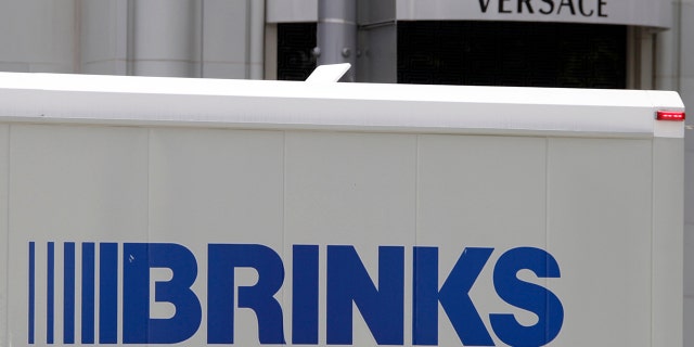 The logo of a Brinks truck is seen near the logo of a Versace store on Rodeo Drive in Beverly Hills, California, May 21, 2013. A Brinks security guard was shot Tuesday at a Houston shopping mall.