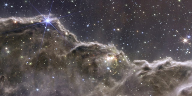 A composite image of the Cosmic Cliffs in the Carina Nebula, created with NIRCam and MIRI instrument data from NASA's James Webb Space Telescope, a revolutionary apparatus designed to peer through the cosmos to the dawn of the universe and released July 12, 2022.