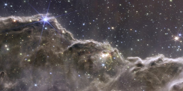 Imagem composta dos penhascos cósmicos na Nebulosa Carina, criada com dados de instrumentos NIRCam e MIRI do Telescópio Espacial James Webb da NASA, um instrumento revolucionário projetado para olhar através do universo até o amanhecer do universo e lançado em 12 de julho de 2022. 