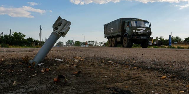 A Russian military truck overtakes an unexploded ordnance during the Ukrainian-Russian conflict in the Russian-controlled village of Chernovaivka, Ukraine, July 26, 2022.