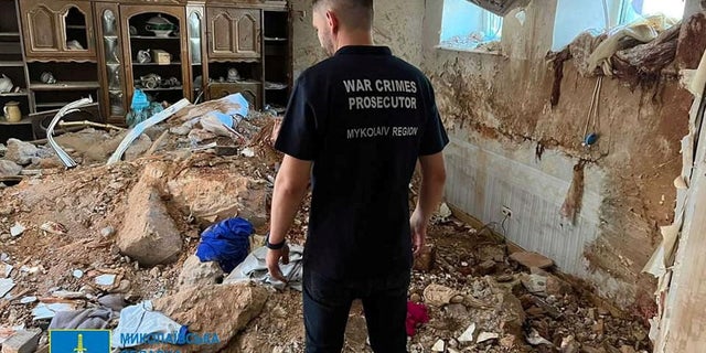 A war crimes prosecutor examines the damage in a destroyed building, as Russia's attack on Ukraine continues, following shelling in Mykolaiv, Ukraine, in this handout picture released on July 31, 2022. Reuters