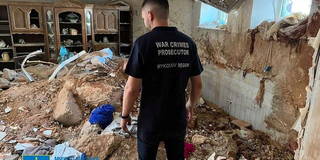 A war crimes prosecutor examines the damage in a destroyed building, as Russia's attack on Ukraine continues, following shelling in Mykolaiv, Ukraine, in this handout picture released on July 31, 2022. Press service of the Mykolaiv Regional Prosecutor's Office/Handout via REUTERS ATTENTION EDITORS - THIS IMAGE HAS BEEN SUPPLIED BY A THIRD PARTY. NO RESALES. NO ARCHIVES