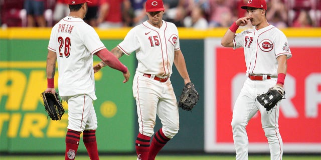 Cincinnati Reds center fielder Nick Senzel (15) celebrates with left fielder Tommy Pham (28) and right fielder Stuart Fairchild (57) after defeating the Miami Marlins in a baseball game Monday, July 25, 2022, in Cincinnati.