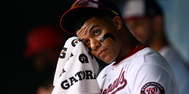 Juan Soto des Nationals s'essuie le visage dans la pirogue avant le match des Braves d'Atlanta, dimanche 17 juillet 2022, à Washington.