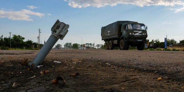 A Russian military truck drives past an unexploded munition during Ukraine-Russia conflict in the Russia-controlled village of Chornobaivka, Ukraine July 26, 2022.
