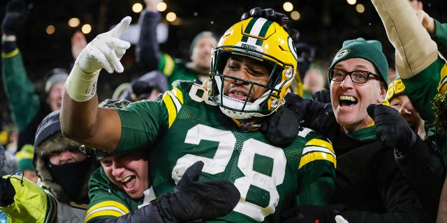 FILE - Green Bay Packers' AJ Dillon celebrates with fans after rushing for a touchdown during the second half of an NFL football game against the Seattle Seahawks, Sunday, Nov. 14, 2021, in Green Bay, Wis.