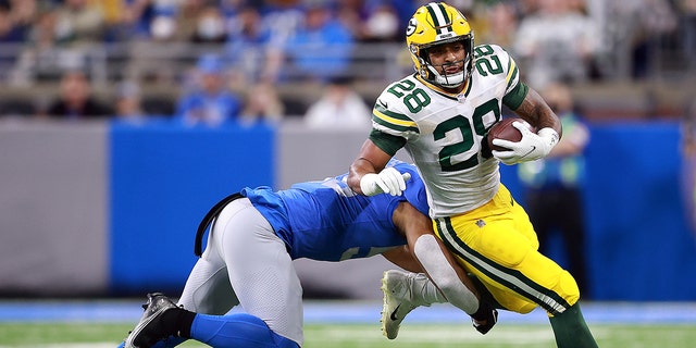 #28 AJ Dillon of the Green Bay Packers carries the ball against the Detroit Lions in the first quarter at Ford Field on January 9, 2022 in Detroit, Michigan.
