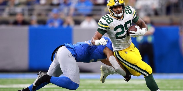 A.J. Dillon #28 of the Green Bay Packers carries the ball against the Detroit Lions during the first quarter at Ford Field on January 09, 2022 in Detroit, Michigan.