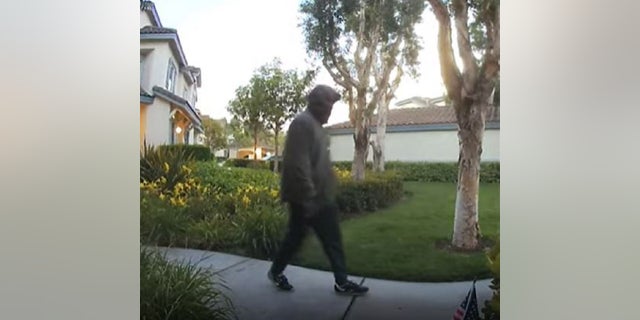 An unidentified suspect walks past a security camera toward a home just before a loud explosions is heard.