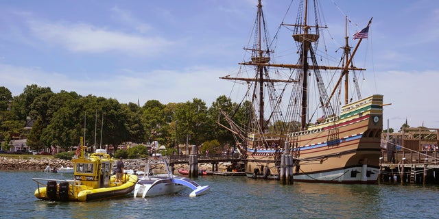 Brett Phaneuf stands on the deck of a tow boat as the Mayflower Autonomous Ship is guided next to the replica of the original Mayflower, on Thursday, June 30, 2022, in Plymouth, Mass. 