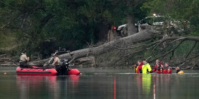Teams in dry suits and Ramsey County Sheriff's deputies search for the bodies of a mother and her three children at Vadnais Lake, Saturday, July 2, 2022, in Vadnais Heights, Minn. 